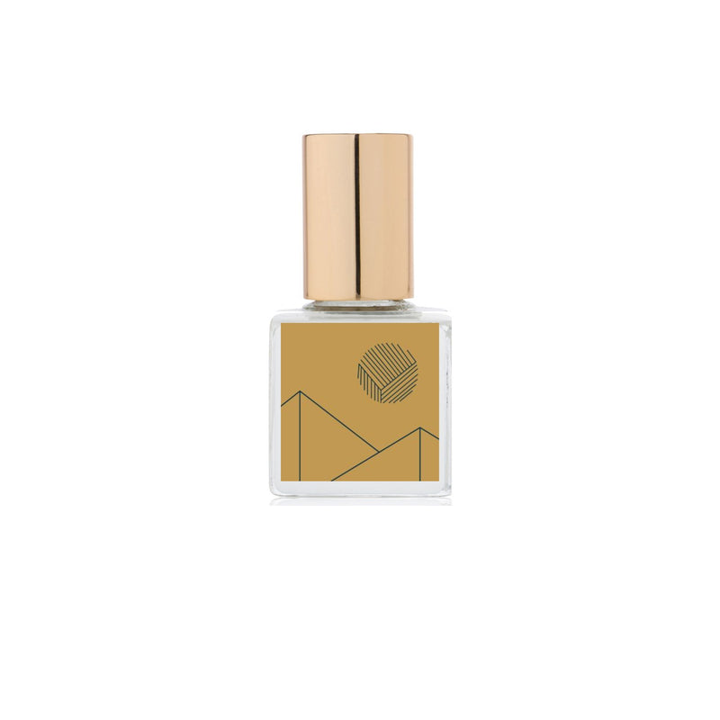 A bottle of Kelly + Jones MEZCAL AÑEJO Perfume Oil Roll-On with a gold-colored label and cap, set against a white background.