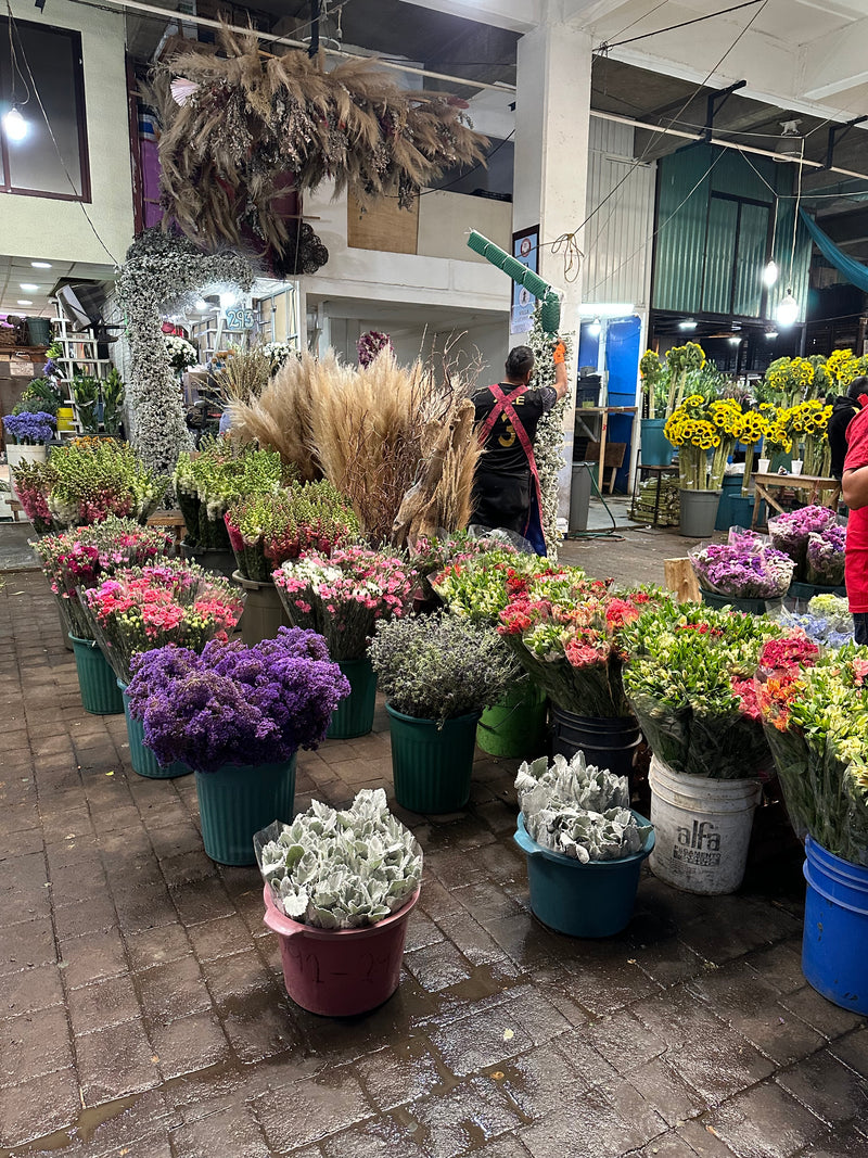 Floral arrangement stand with various flowers in pots at the Mexico City flower market.